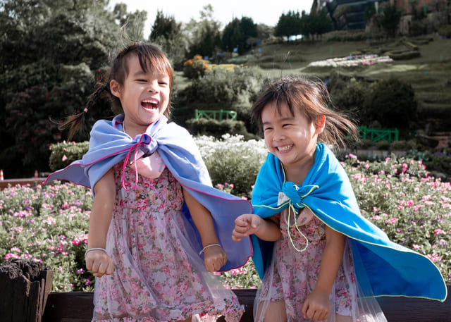 640-two-little-girls-in-the-shawl-plays-superhero-smile-happily-in-the-garden