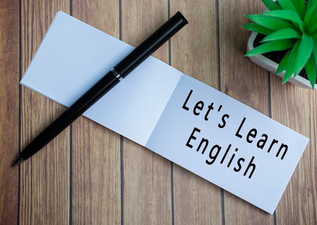 640-lets-learn-english-text-on-notepad-with-potted-plant-on-a-wooden-desk